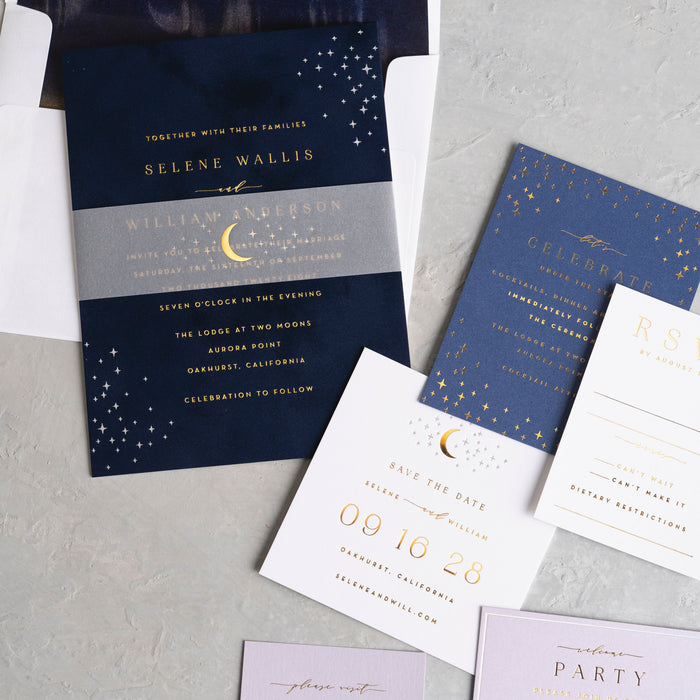 Selene Wedding invitation set with navy and gold design on a gray surface