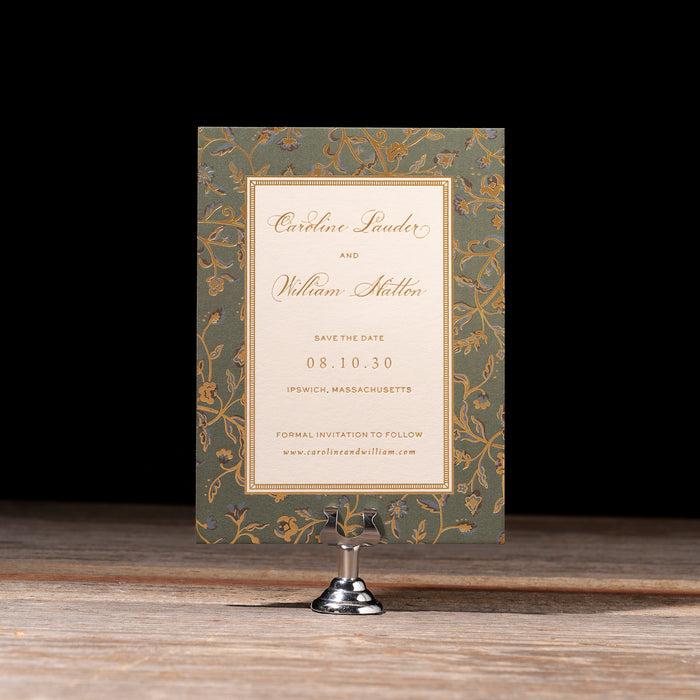 Decorative Charmain Save the Date Card on a stand with a dark background