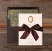 Charmain Invitation card with brown bow on a wooden surface