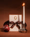 Stationery set with a pomegranate, card, and candle on a brown background