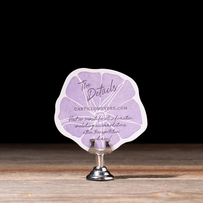 Purple details  card with text on a wooden stand against a dark background