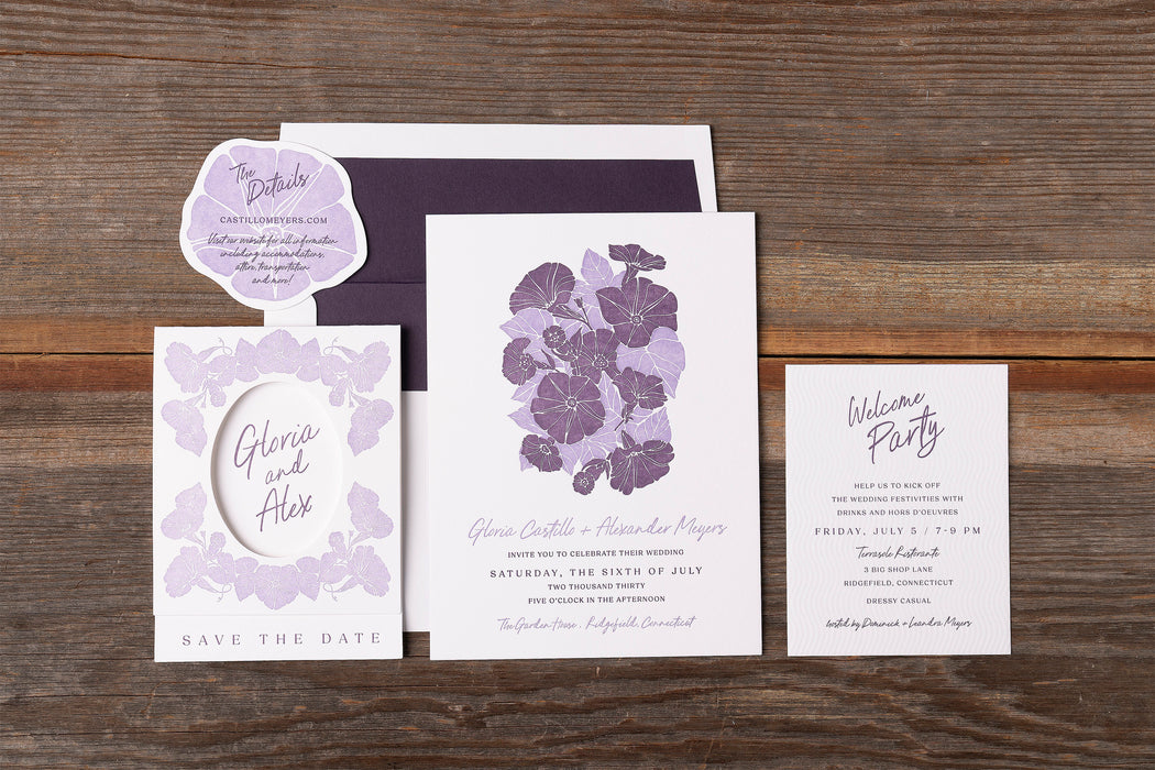 Gloria Wedding invitation set with floral design on a wooden surface