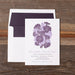Gloria Wedding invitation with purple floral design on a wooden surface