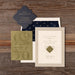 Albright Wedding invitation set on a wooden surface with a green card and lined envelope.