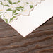 Corner detail of Ashby Wedding Invitation; Floral-patterned paper on a wooden surface