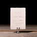 Ashby Save the Date card on a stand with a dark background