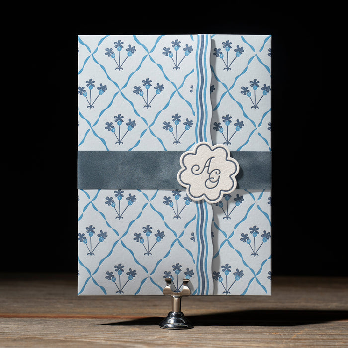 Astrid Wedding Invitation (closed) on a stand against a dark background