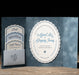 Astrid wedding invitation set with blue and white design on a wooden surface