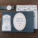 Astrid wedding invitation set with navy blue and white design on a wooden surface