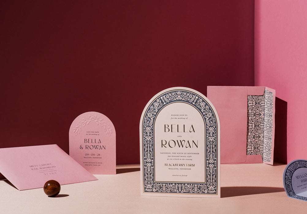 Decorative wedding invitation with 'Bella & Rowan' on a pink background