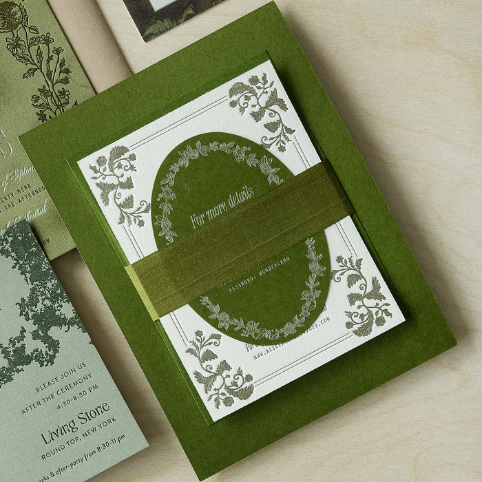 Green and white invitation card with decorative elements on a wooden surface
