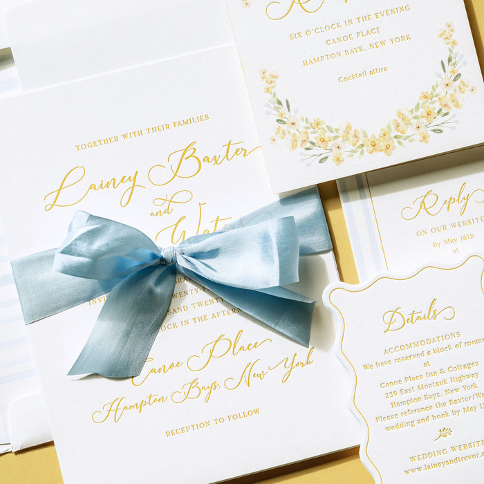 Lainey wedding invitation card with a blue ribbon on a yellow background