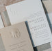 Collection of elegant wedding invitation cards from the Sedna Suite with embossed designs on a textured surface.