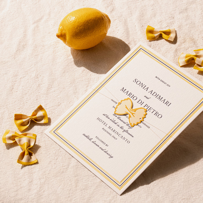 Italo wedding invitation card with lemon and pasta on a textured surface