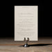 Wedding invitation details card on a stand with a dark background