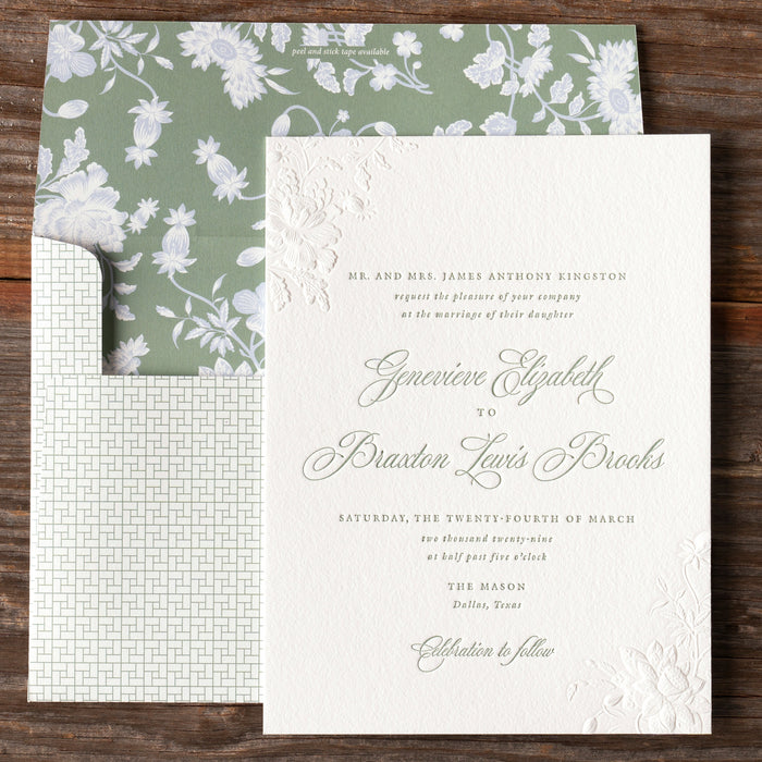 Braxton v2 wedding invitation card with green floral liner on a wooden surface
