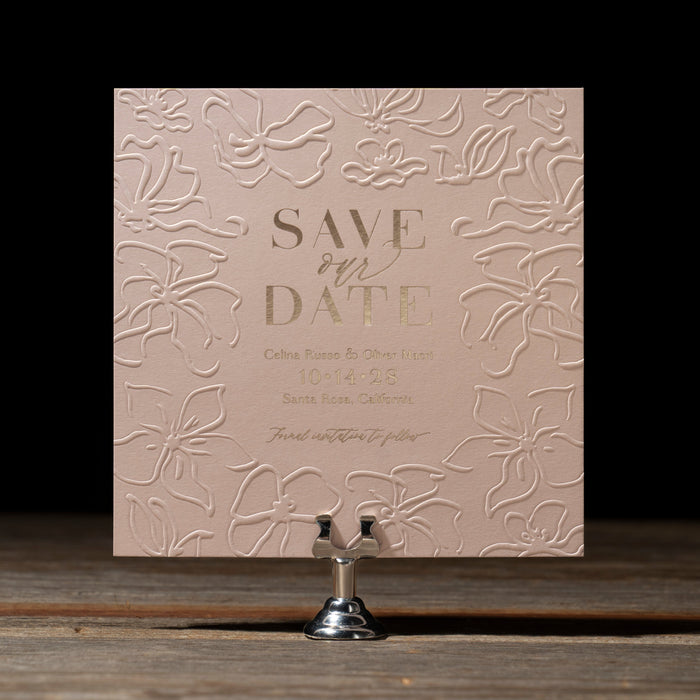 Celina 'Save the Date' card with floral embossing on a dark background