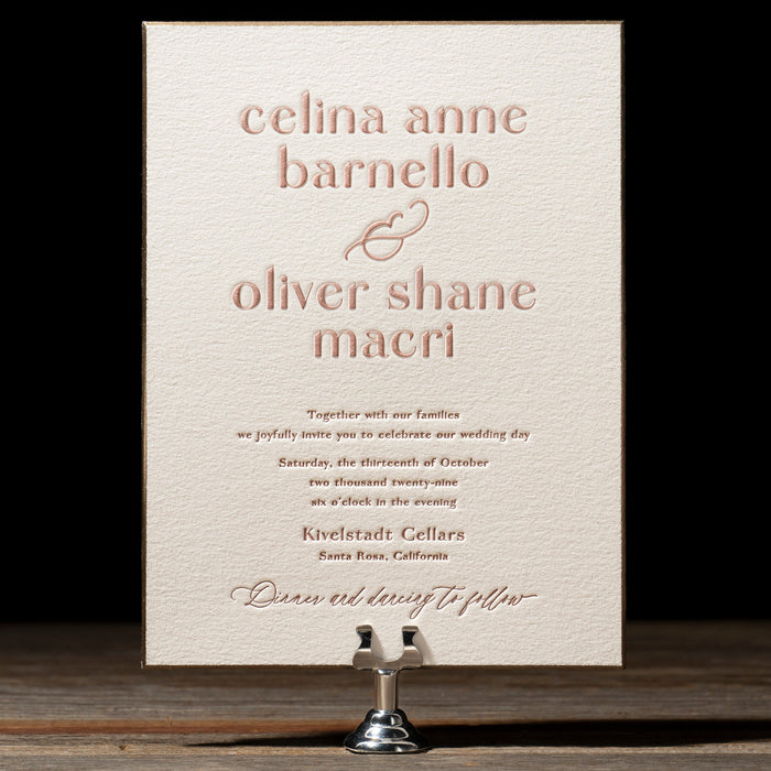 Celina wedding invitation on a stand against a dark background