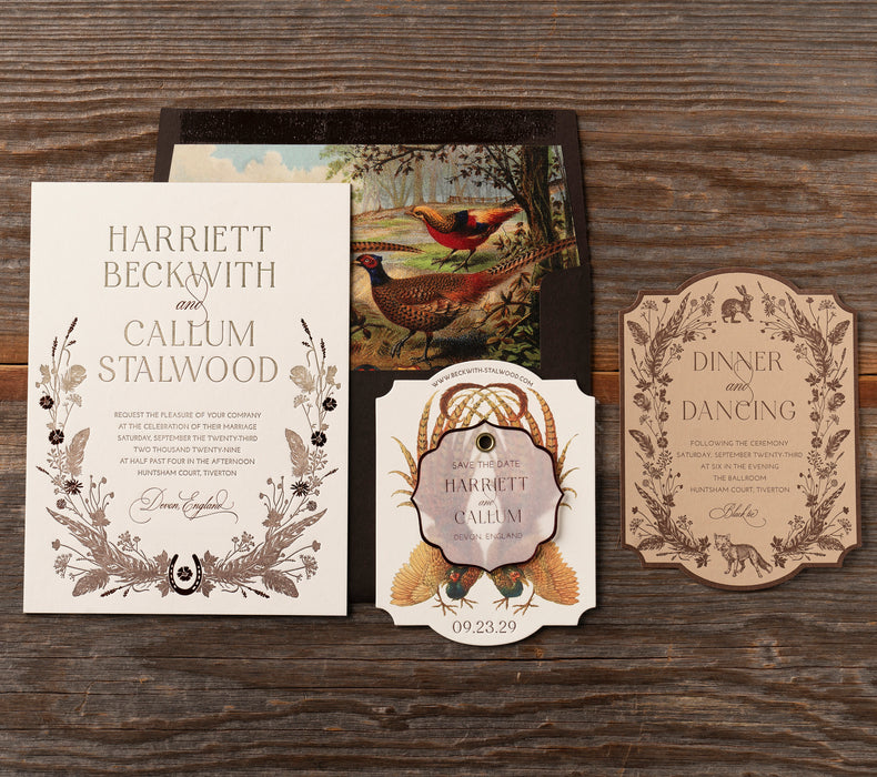 Vintage-style Devonshire wedding invitation set with nature-themed design on a wooden surface
