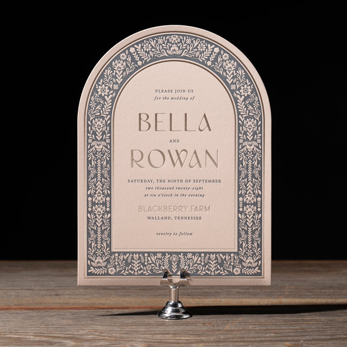 Decorative wedding invitation on a stand with a black background