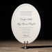 Elegant Gellert oval wedding invitation on a stand with a dark background