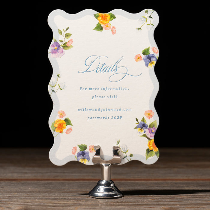 Decorative card with floral designs on a stand against a dark background