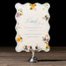 Decorative card with floral designs on a stand against a dark background