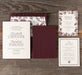 Harkness wedding invitation set with burgundy and floral design on a wooden surface