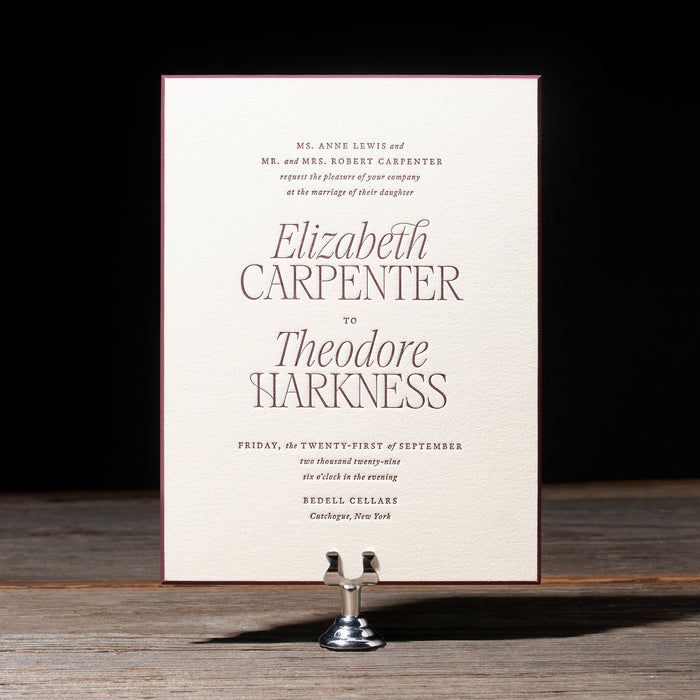 Harkness Wedding invitation card on a stand with a dark background