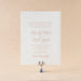 Elegant Heaton wedding invitation card on a beige background with a candle holder.
