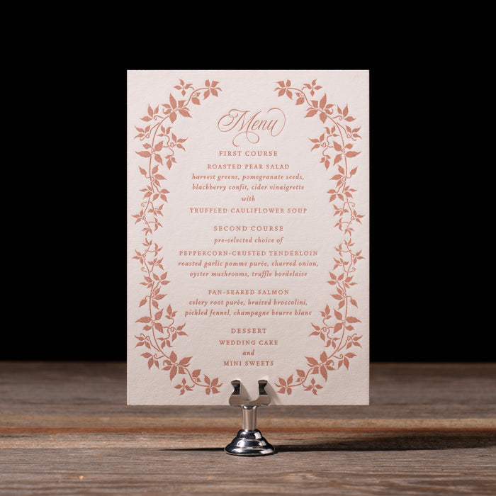 Wedding menu with floral design on a stand against a dark background