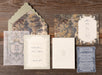 Collection of vintage-style wedding invitation pieces from Isolde Suite on a wooden surface