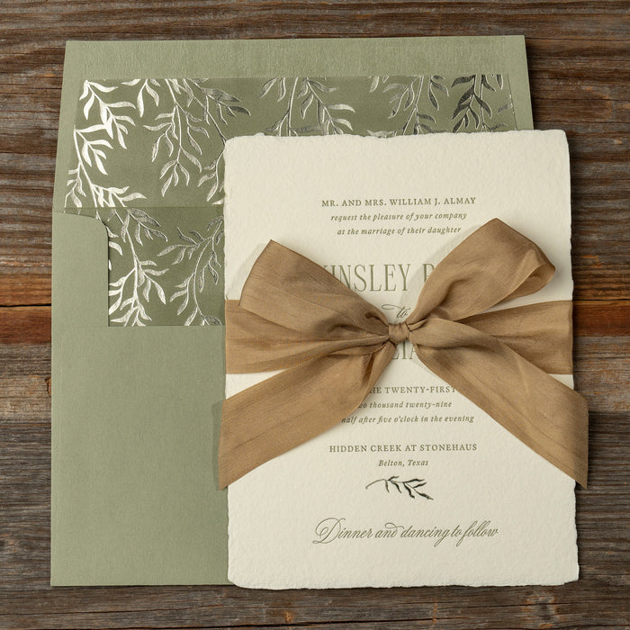 Kinsley wedding invitation with silk bow on wood background