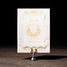 Decorative card on a stand with gold accents against a dark background