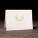 Thank you card with gold floral design and text on a wooden surface
