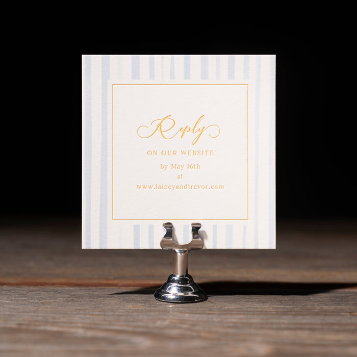 Reply card with gold text on a stand against a dark background