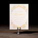 Wedding reception card with floral design on a stand against a dark background