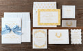 Lainey invitation with yellow and white designs on a wooden surface.