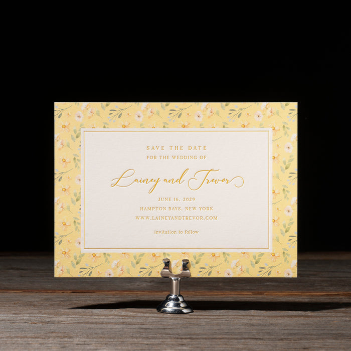 Wedding save the date card on a stand with a yellow floral border