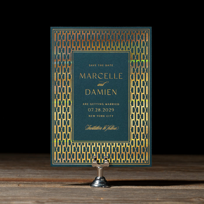 Art Deco inspired Wedding Save the Date from Marcelle suite on a stand with a dark background