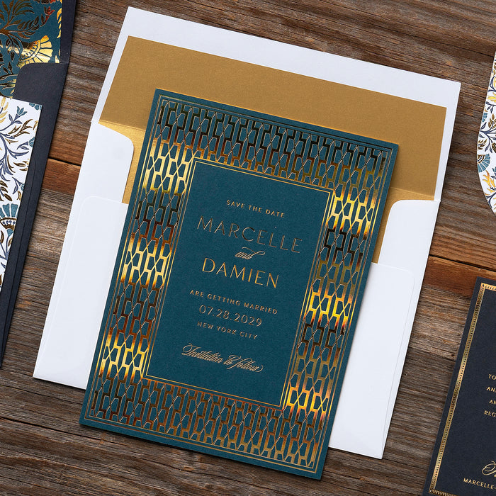 Decorative wedding save the date card with gold and blue Art Deco design on a wooden surface