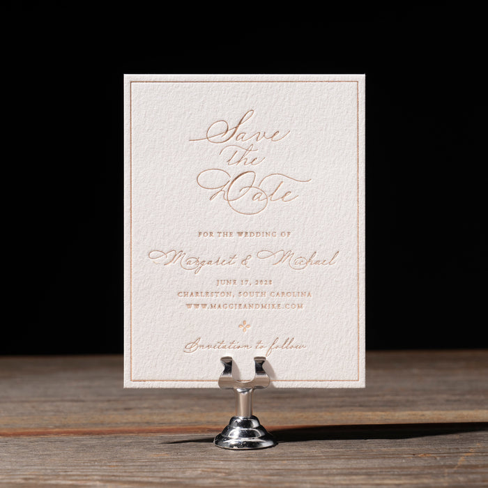 Save the Date card on a stand with a dark background