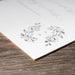 White paper with black floral design on a wooden surface
