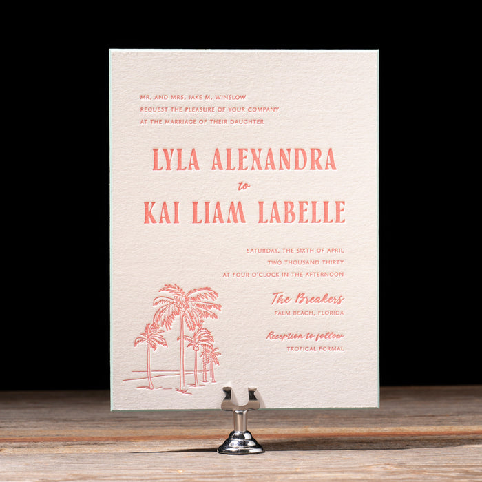 Palmer wedding invitation card with palm tree design on a wooden surface and black background