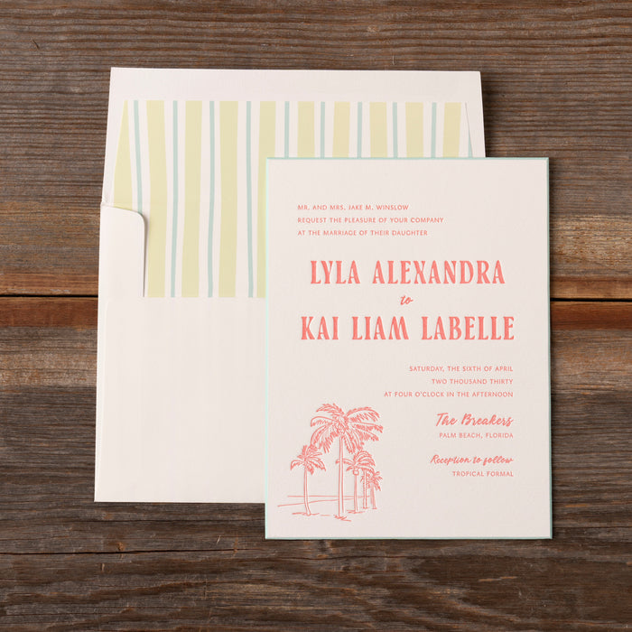 Palmer Wedding invitation card with palm tree design on a wooden surface
