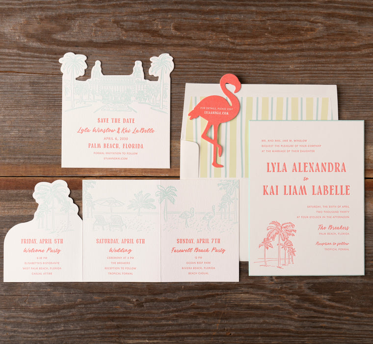 Set of wedding invitations with a flamingo design on a wooden surface