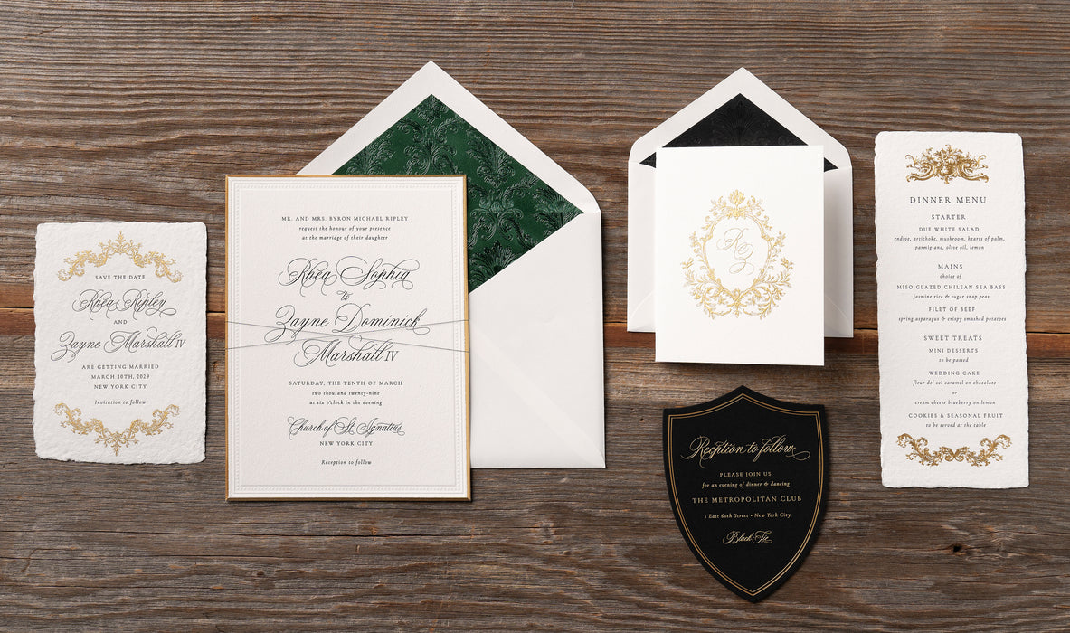 Rhea wedding invitation suite and menu cards on a wooden surface