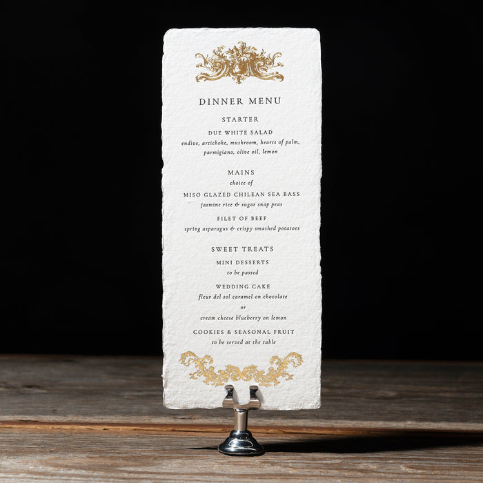Rhea Dinner menu on a stand with a dark background