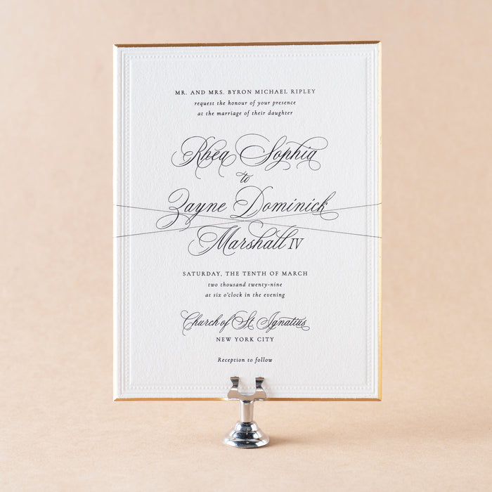 Rhea Wedding invitation card on a beige background.