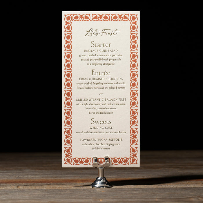 Royce menu card with decorative border on a stand against a dark background